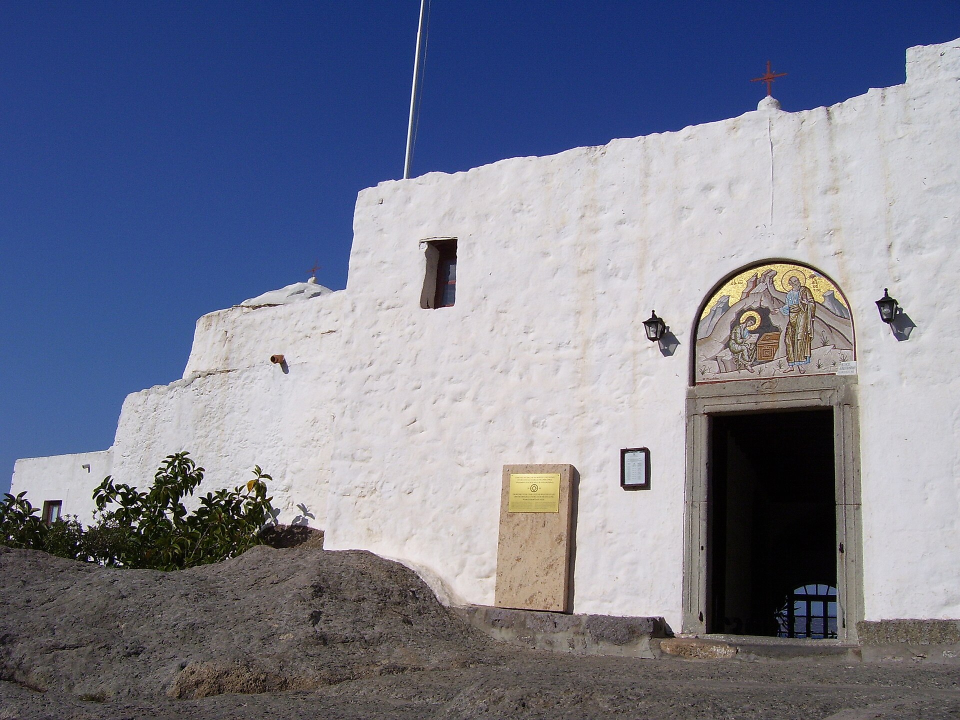 Der weiße Eingang zur Höhle der Offenbarung auf Patmos unter blauem Himmel