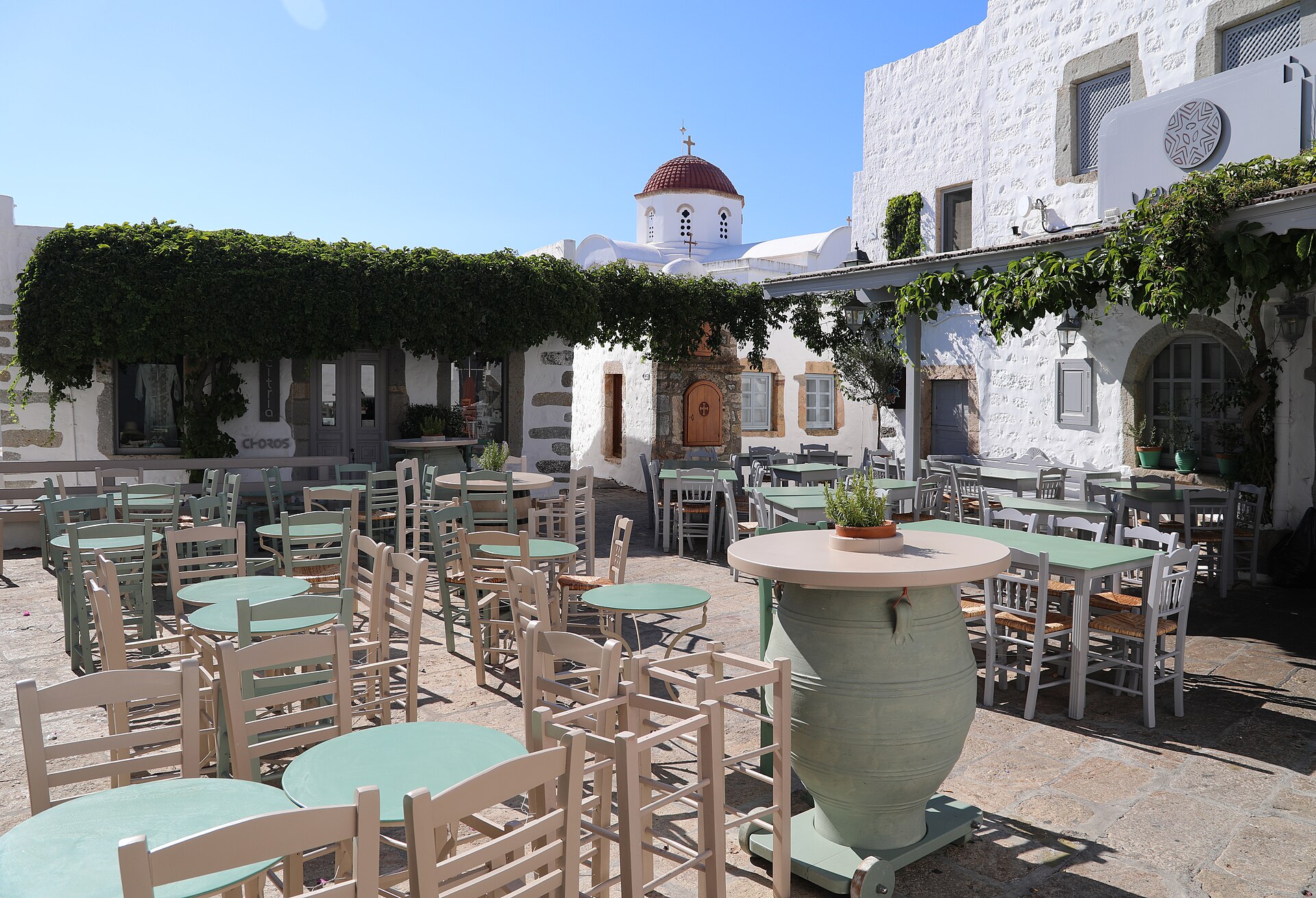 Kleiner Platz in der Chora mit Tischen einer Taverne unter Weinlaub