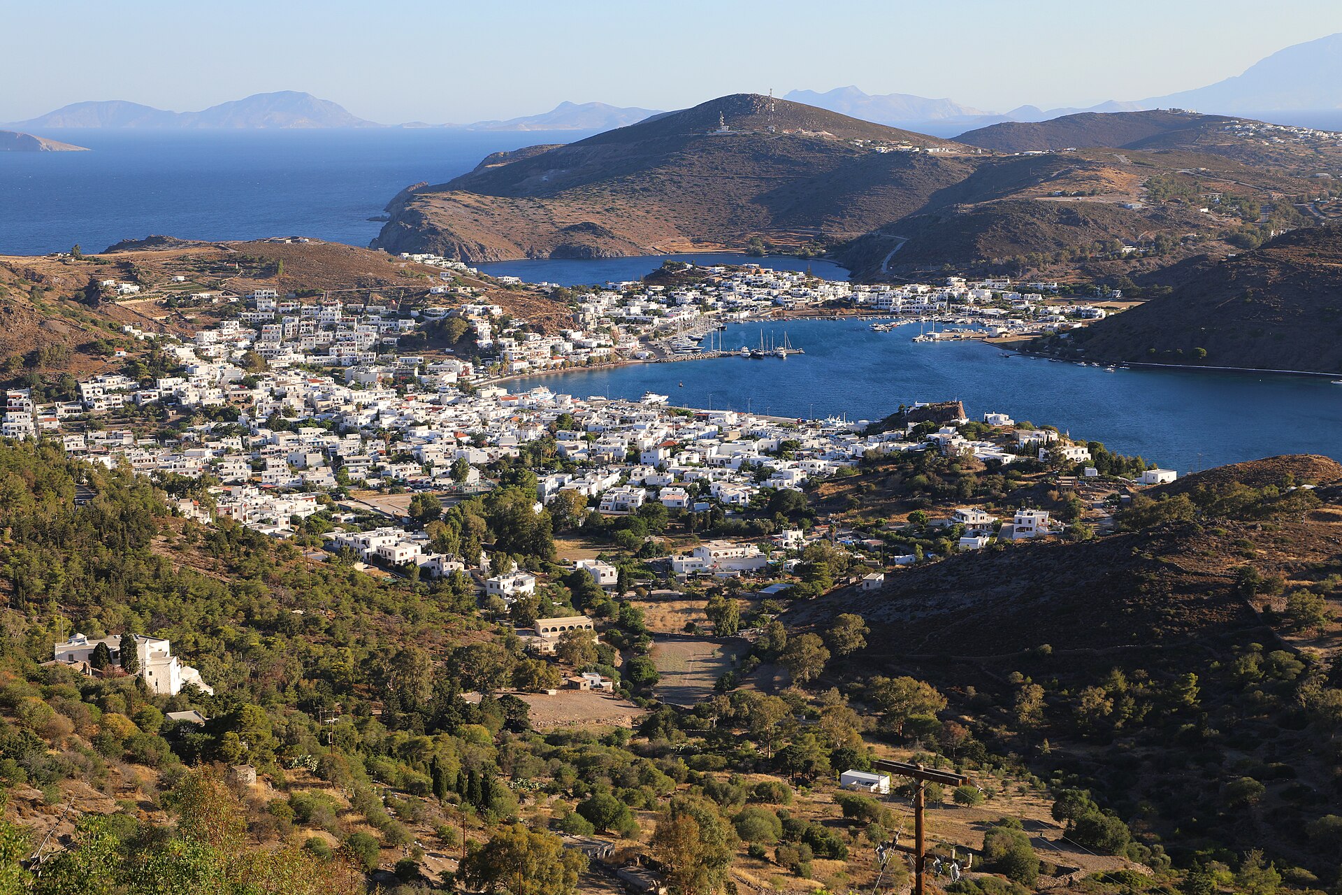 Blick von den Windmühlen der Chora hinunter auf den Hafen Skala, die weißen Häuser und die Buchten von Patmos